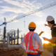 A team of construction engineers talks to managers and construction workers at the construction site